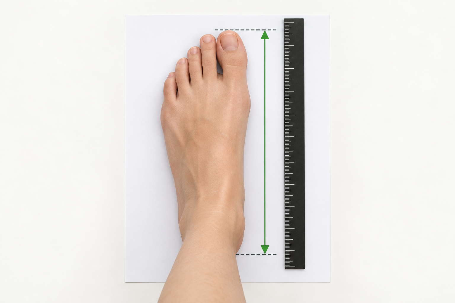 Foot placed on paper with a ruler measuring from heel to longest toe